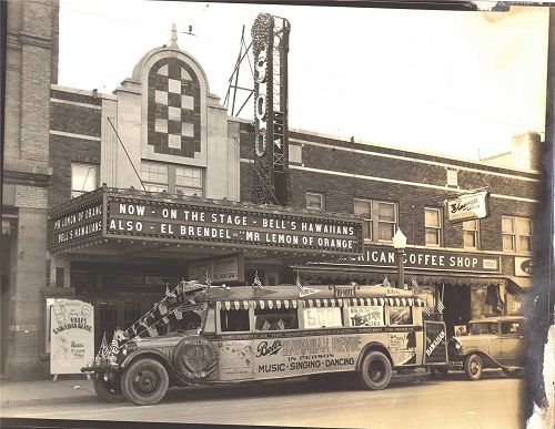 Bell's Hawaiian Revue bus in front of the Soo Theatre with original marquee